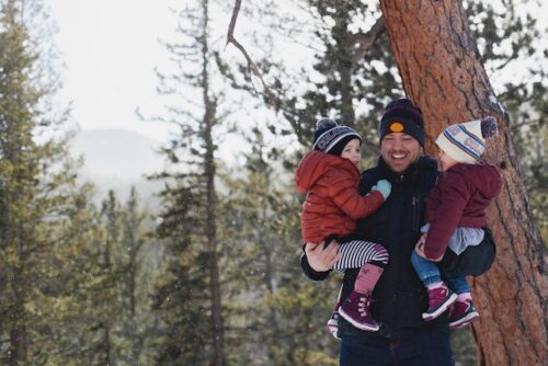 father carrying two kids