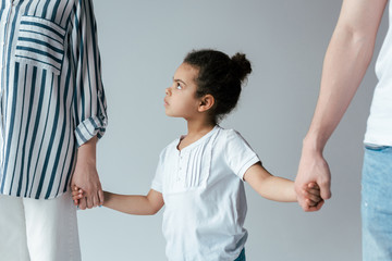 child standing between parents