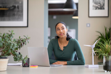 woman on computer looking contemplative