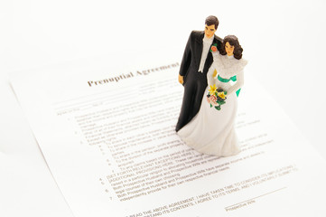 husband and wife cake topper on prenuptial agreement